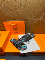 Hermes slide sandals with black strap and colorful abstract pattern on the upper