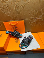 Hermes sandals displayed with black straps and multicolor abstract print footbed