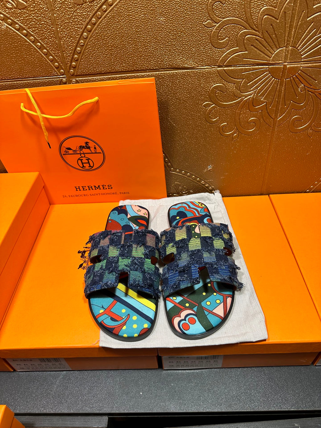Blue patterned slide sandals with chunky toe straps and frayed ankle wrap