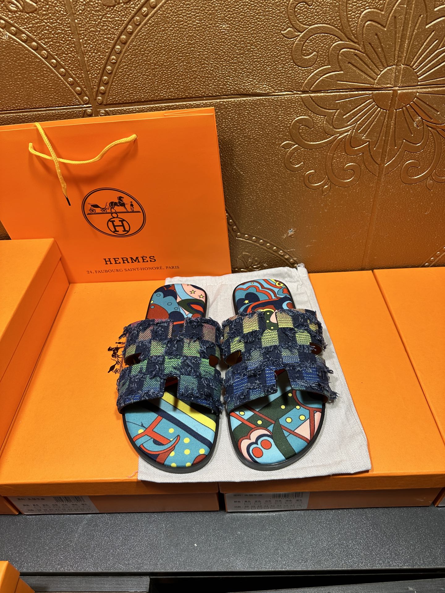 Blue patterned slide sandals with chunky toe straps and frayed ankle wrap