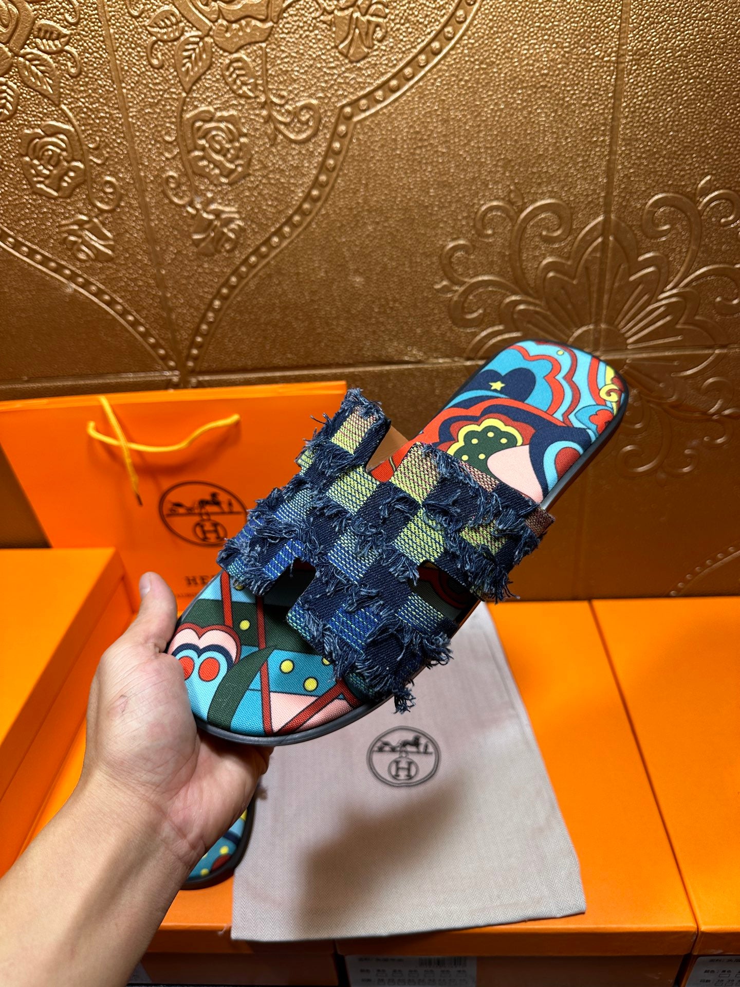 Blue patterned slide sandals with colorful graphic footbed and frayed ankle straps