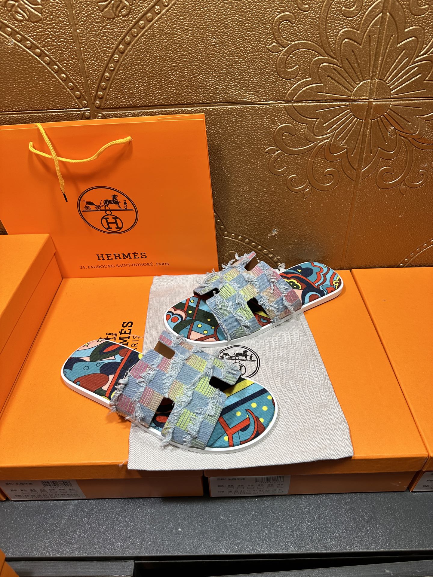 Patchwork Hermes slide sandals, front view with multicolor fabric straps and blue patterned sole