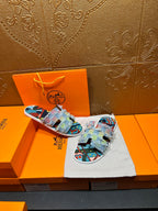 Hermes patchwork slide sandals, side view on cloth with multicolor graphic fabric straps