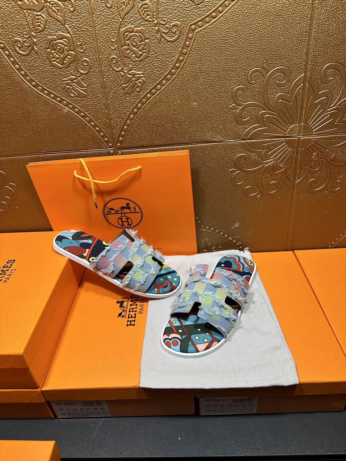 Hermes patchwork slide sandals, side view on cloth with multicolor graphic fabric straps