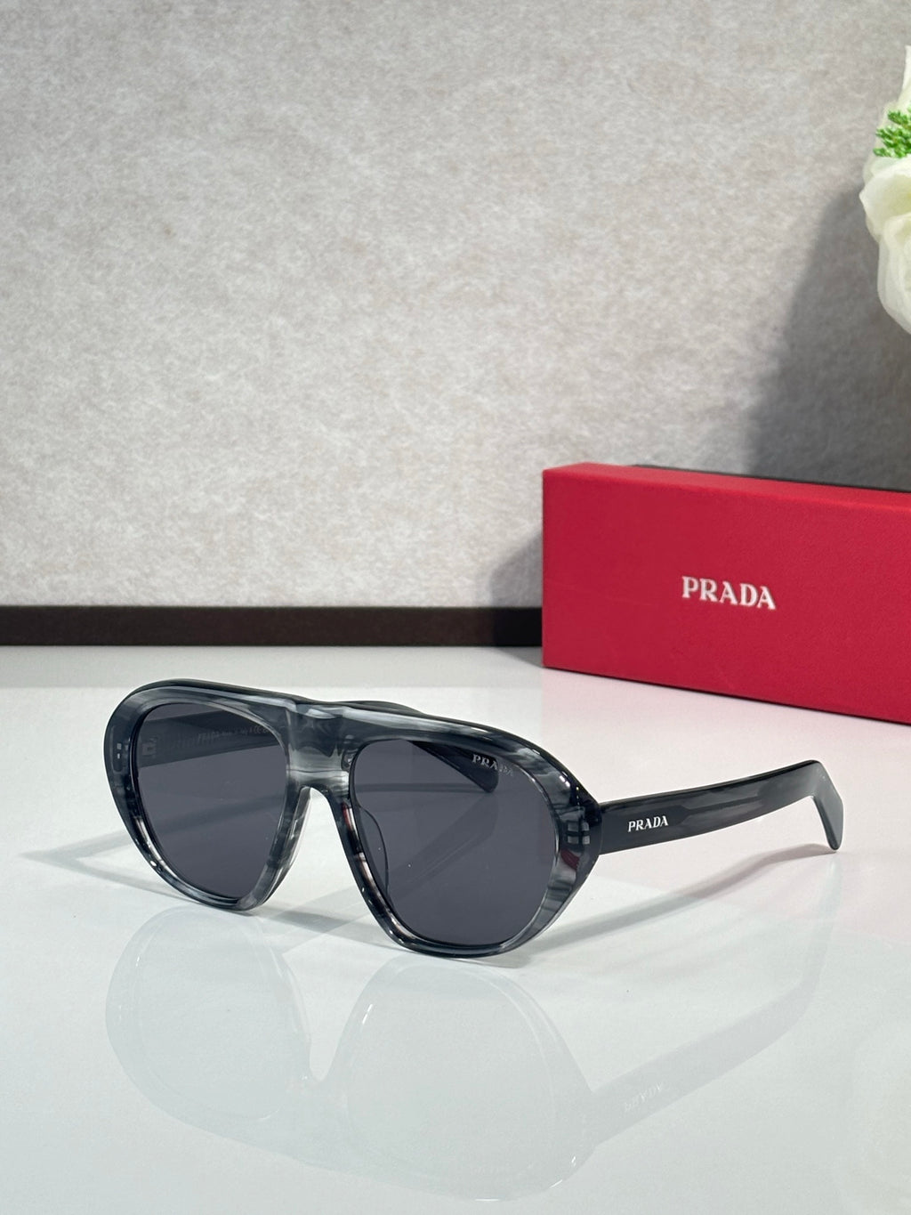 Prada oversized cat-eye sunglasses with dark blue-black frames and dark lenses