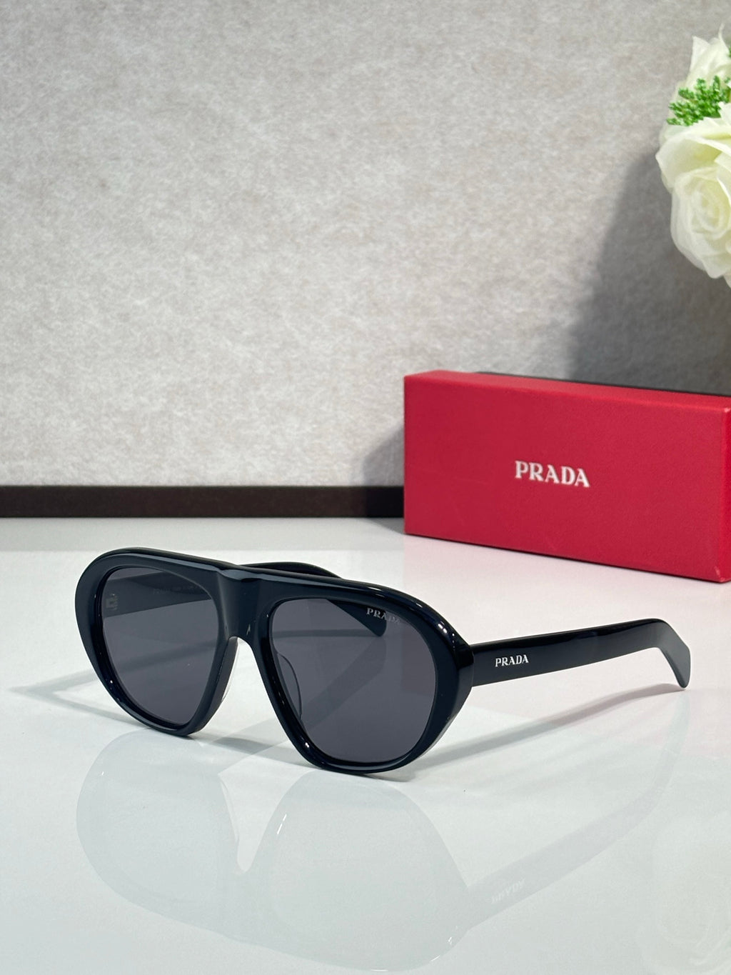 Prada oversized cat-eye sunglasses with dark blue-black frames and dark lenses