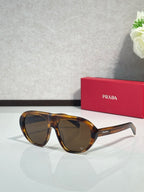 Prada oversized cat-eye sunglasses with tortoiseshell frames and dark lenses