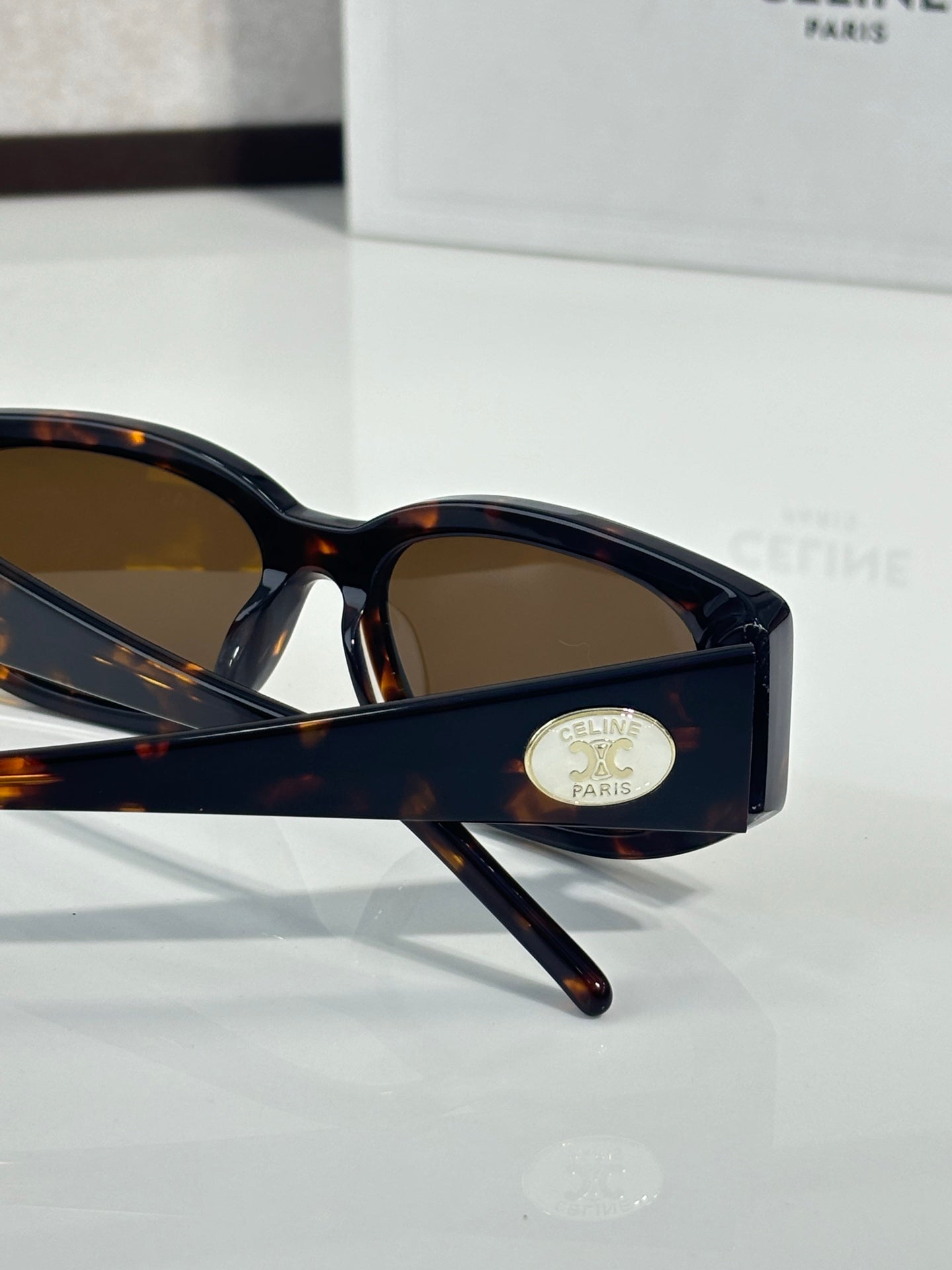 Dark tortoiseshell sunglasses with oval frames and brown lenses