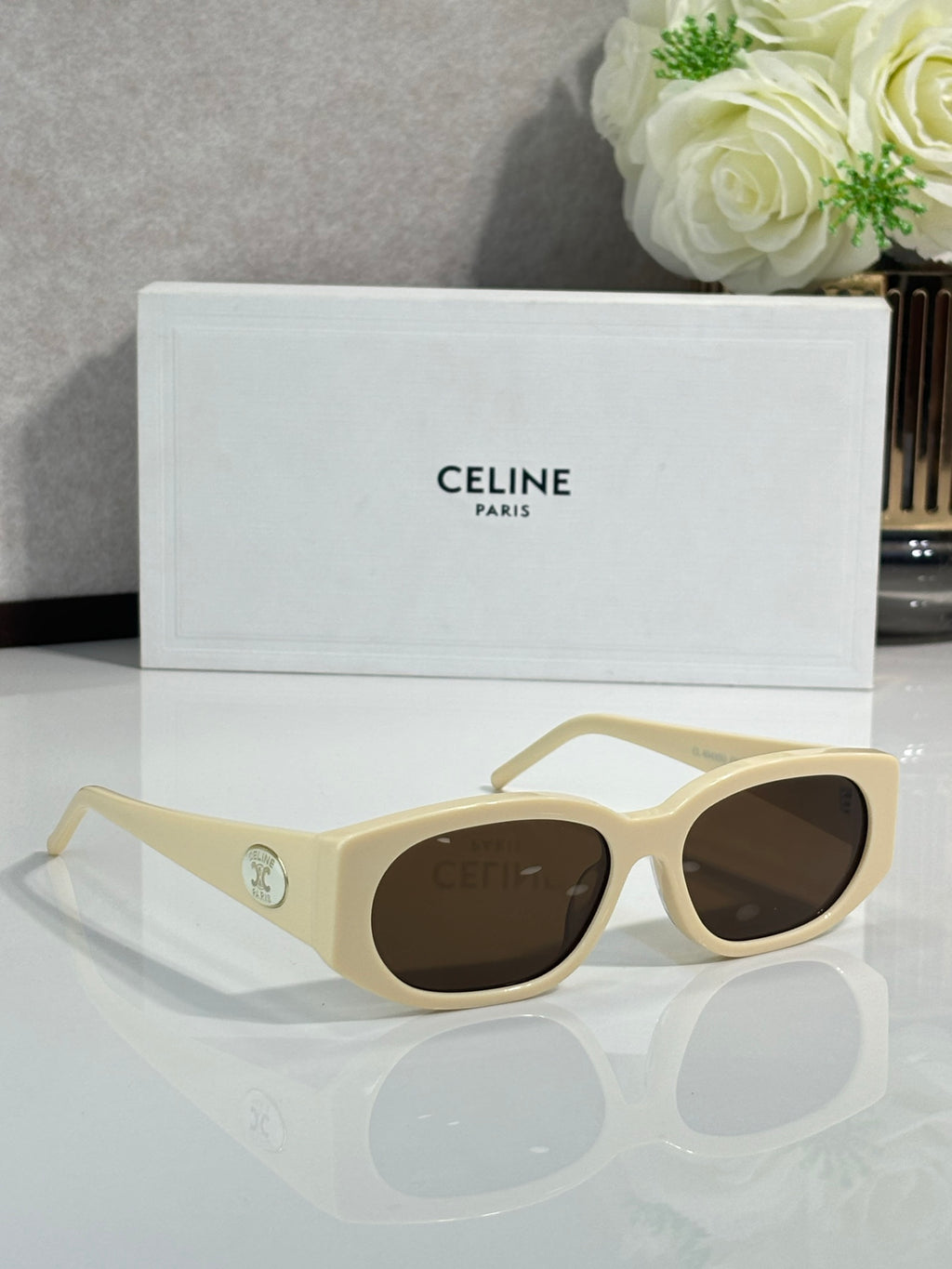 Cream sunglasses with oval frames and brown lenses