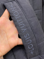 Dark blue jacket strap with vertical Louis Vuitton text