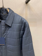Dark blue puffer jacket with raised collar and quilted chest paneling
