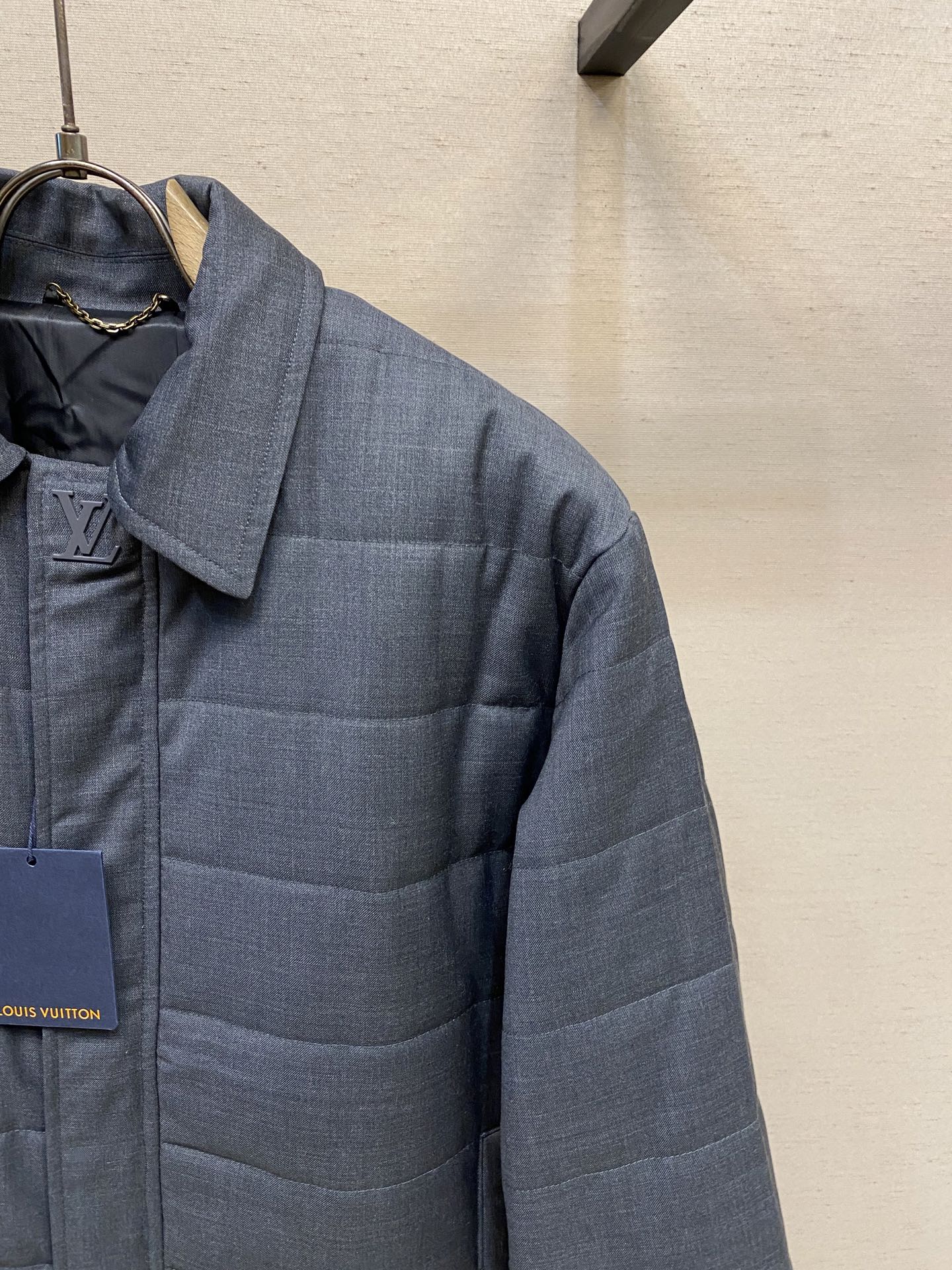 Dark blue puffer jacket with raised collar and quilted chest paneling