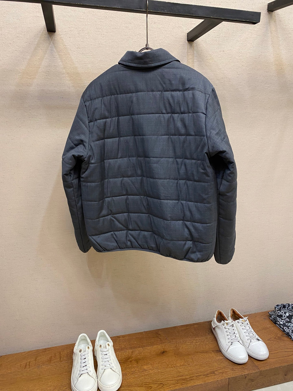 Dark blue puffer jacket, back view with quilted panels and long sleeves