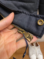 Dark blue jacket cuff with gold-tone button and zipper detail