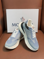 Light blue Moncler sneakers with white laces, stacked heel look, dark collar trim