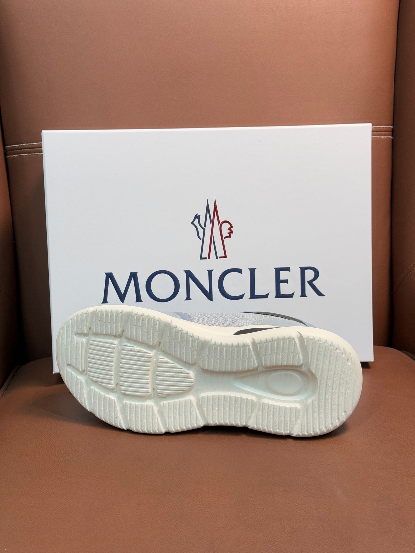 White rubber sole of a light blue Moncler sneaker with textured tread