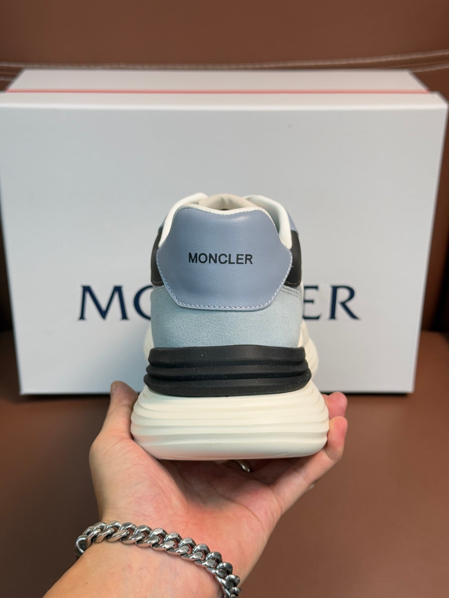 Light blue Moncler sneaker heel close-up with 'MONCLER' on back tab