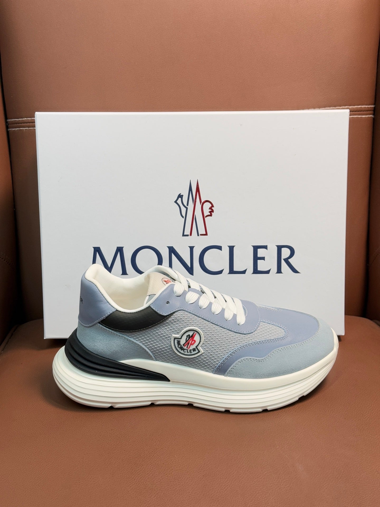 Light blue Moncler sneaker with white laces, side logo patch, off-white ribbed sole