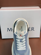 Light blue Moncler sneaker front close-up with white laces and 'MONCLER' on tongue