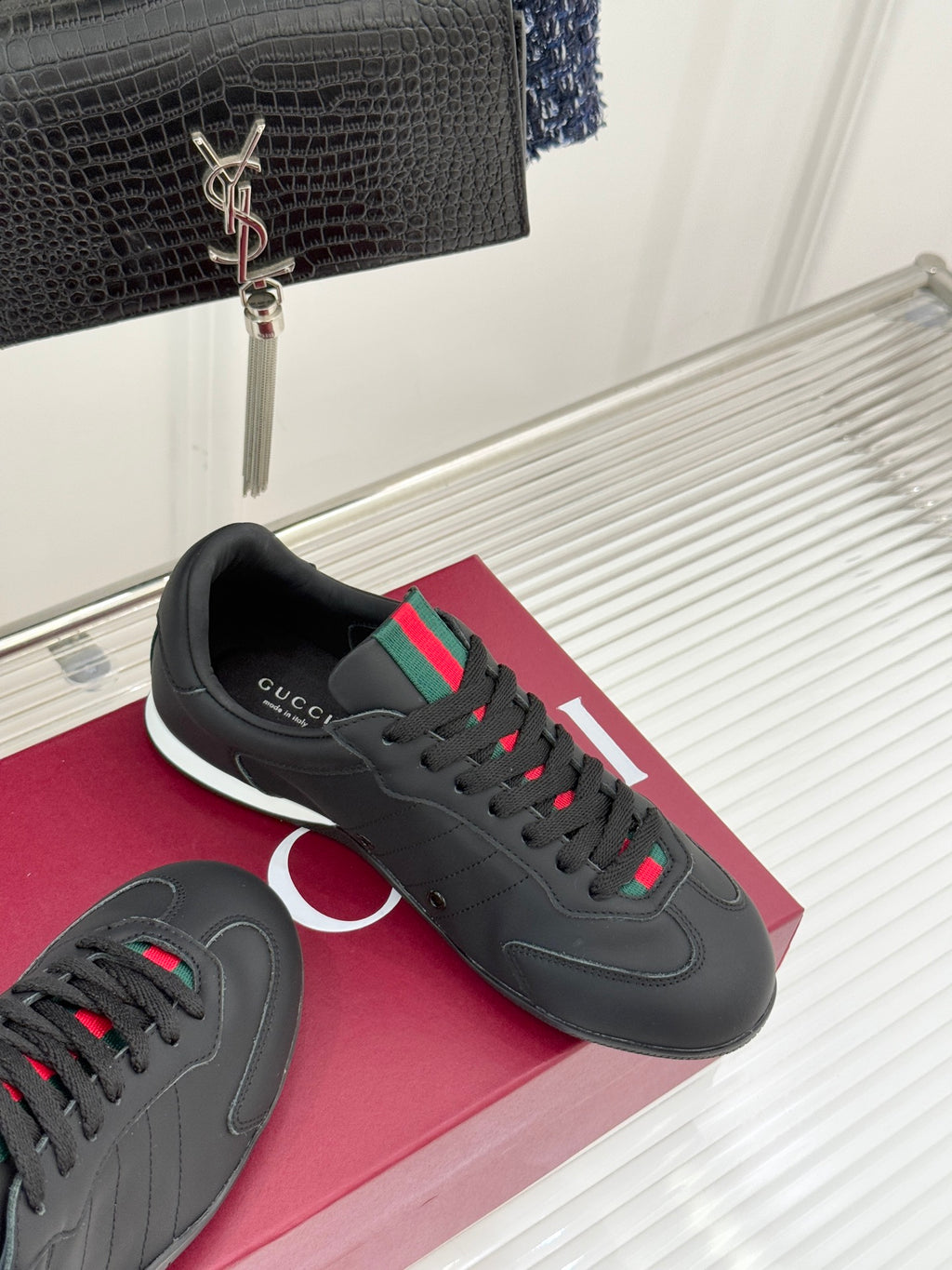 Black Gucci sneakers with red and green stripe accents and dark laces