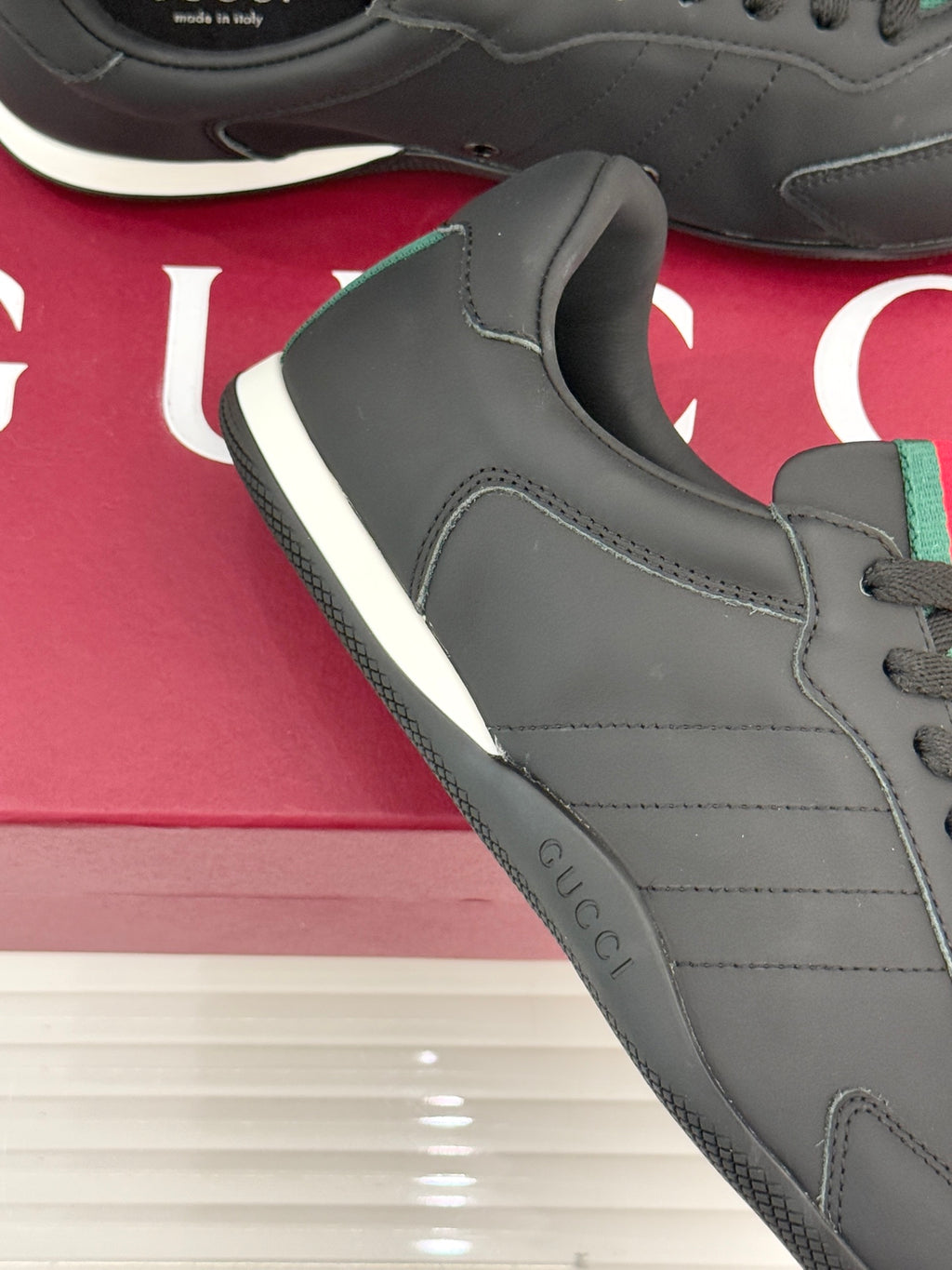 Close-up of black leather sneaker side with stitch lines and lace-up panel