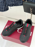 Black lace-up sneaker with multicolor stripe accents, rounded toe, and white midsole