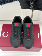 Black leather sneakers facing front with multicolor stripe detail on the tongue area