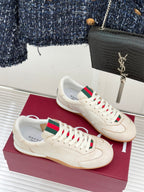 Cream Gucci low-top sneakers on box, green-red web stripe and white laces