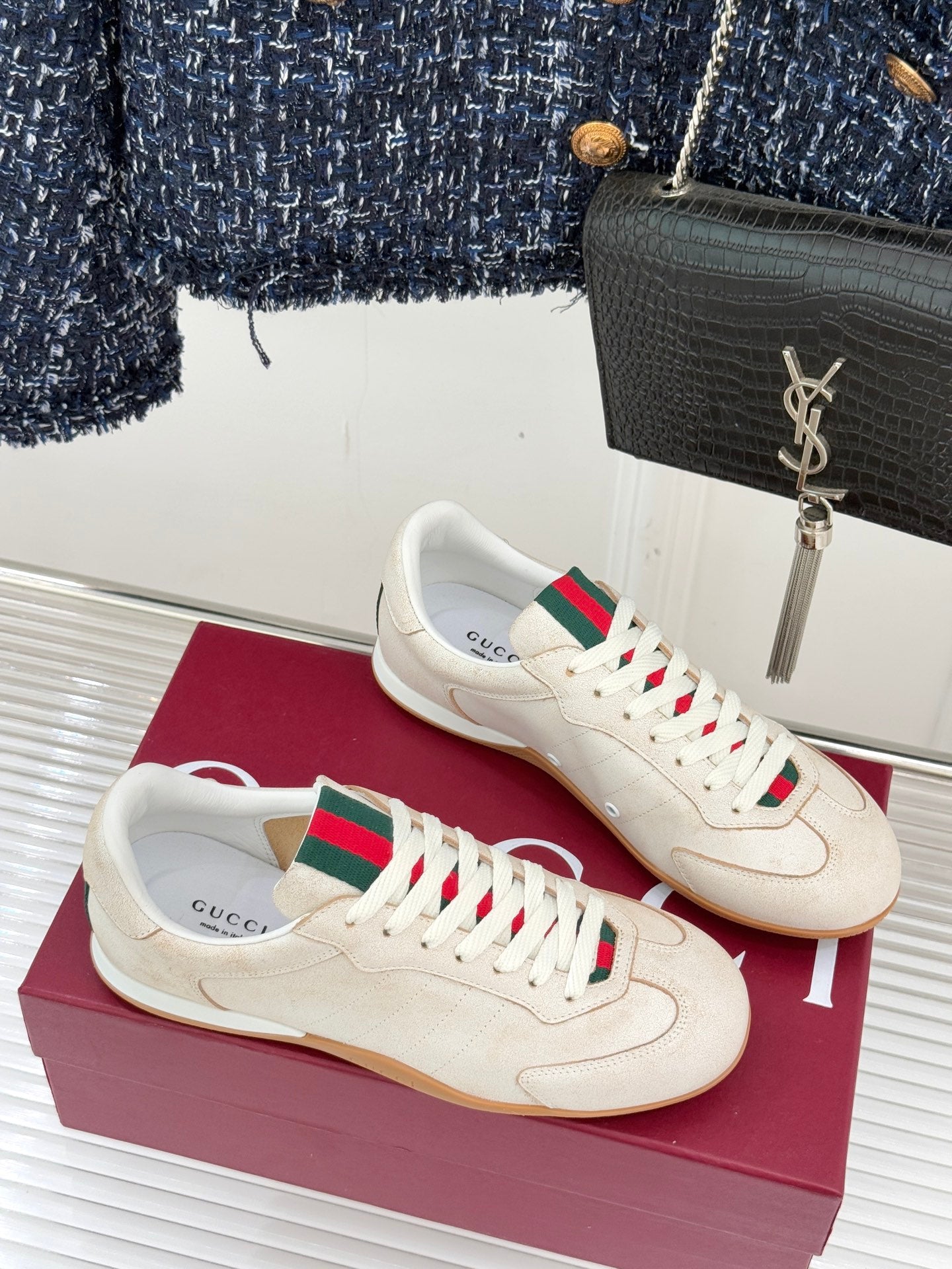 Cream Gucci low-top sneakers on box, green-red web stripe and white laces