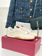 Cream Gucci sneakers with white laces, green-red web stripe detail, gum sole