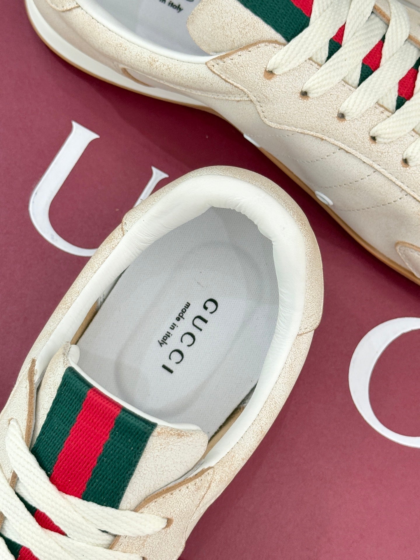 Cream sneaker heel with printed insole branding, green-red web stripe, white laces