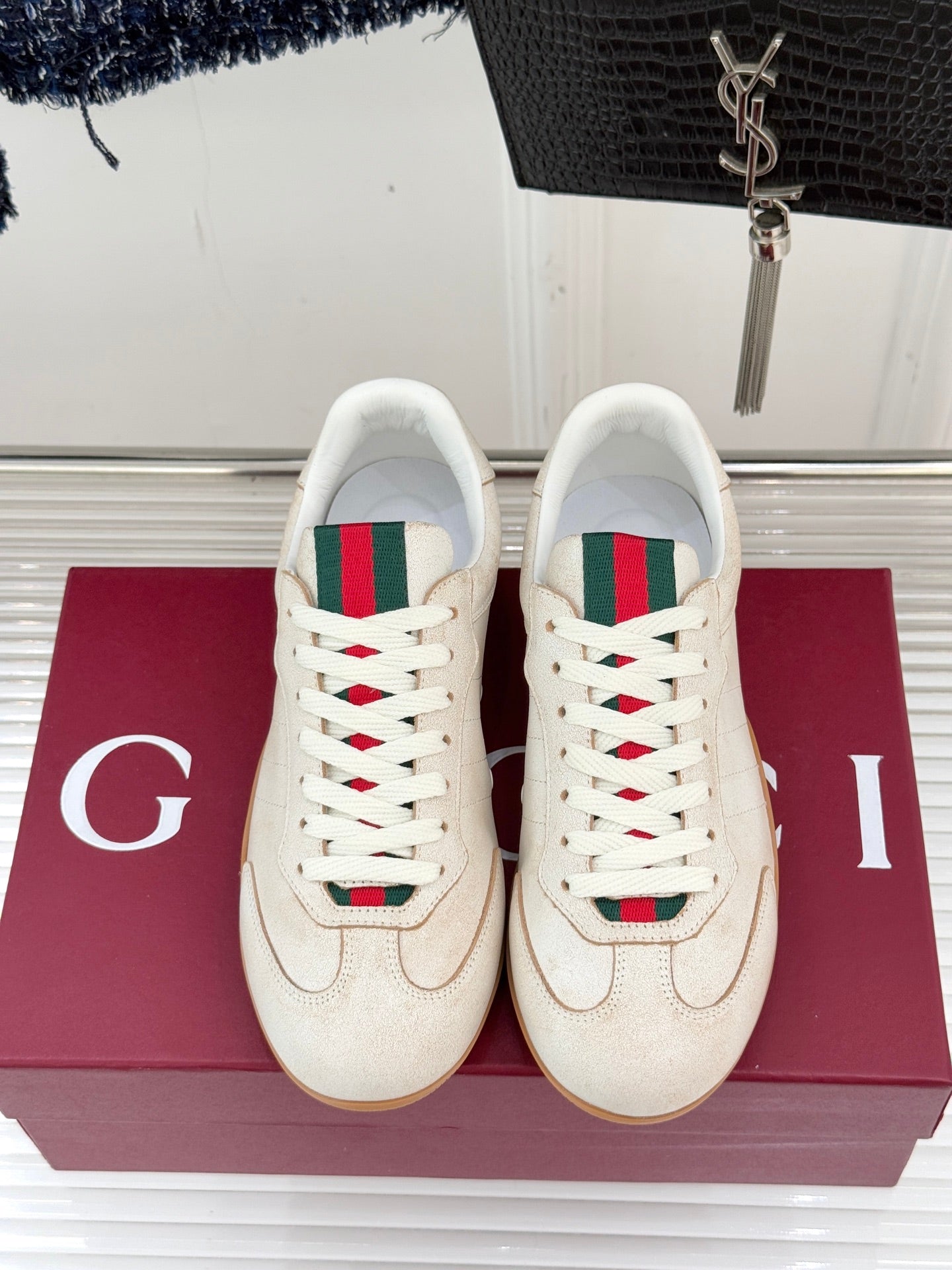 Cream Gucci sneakers, green-red web stripe detail with white laces, front view