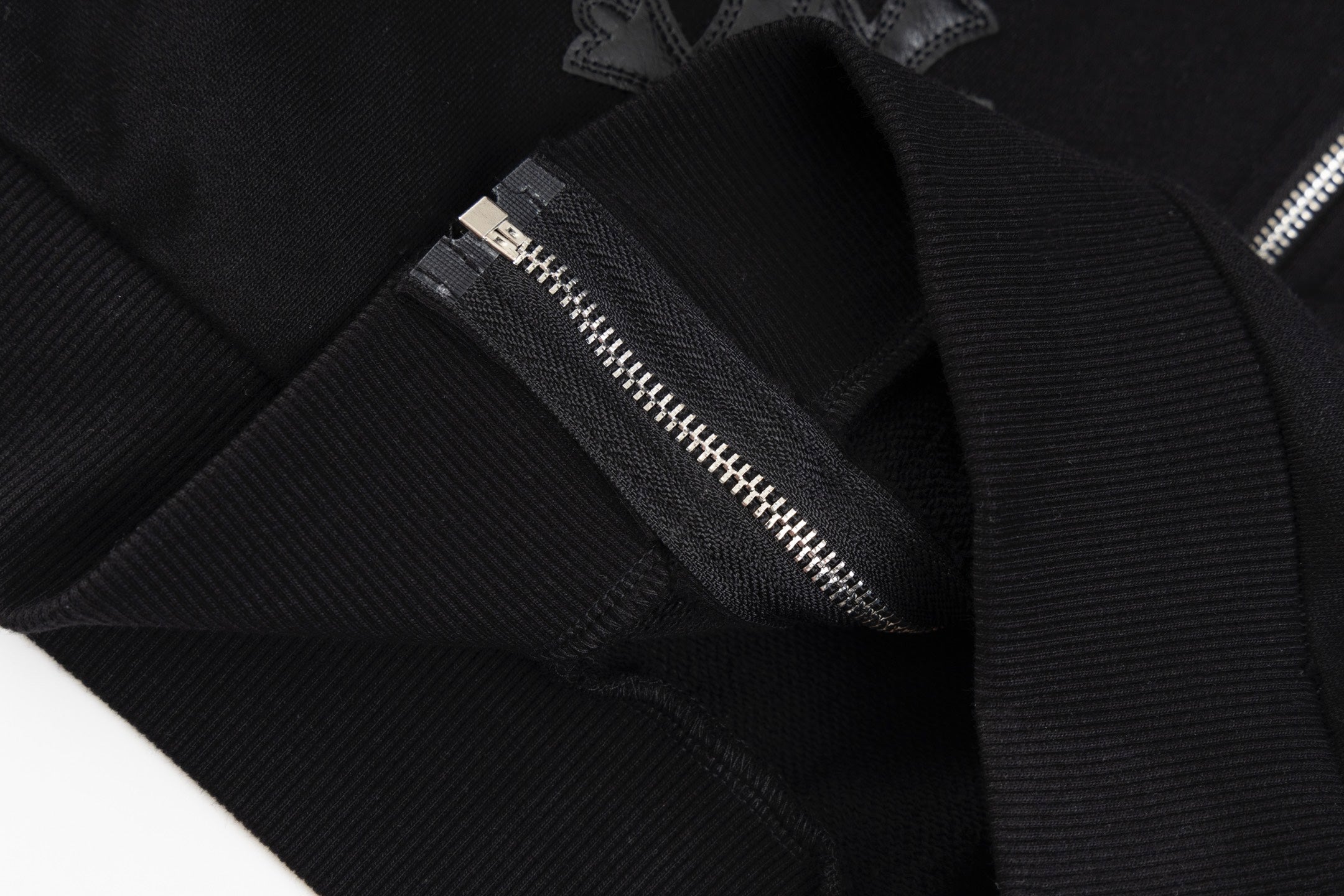 Black long-sleeve hoodie with silver zipper and stitched placket detail
