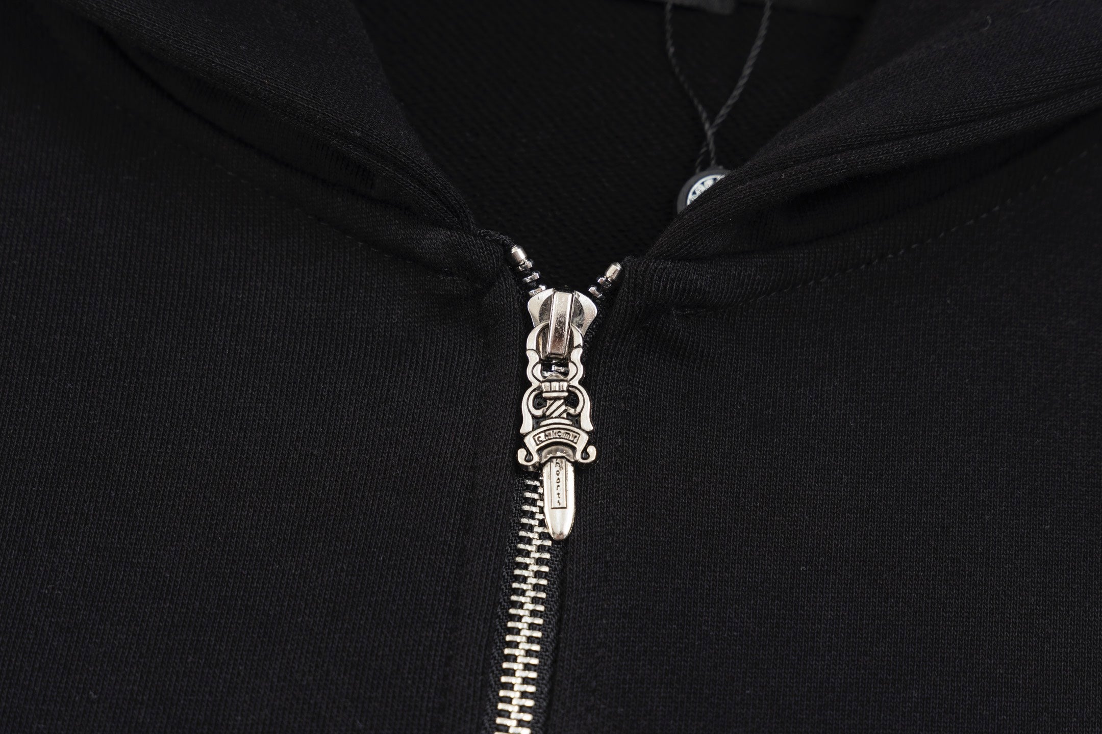 Black hoodie zipper with metal pull tab and hooded neckline hardware