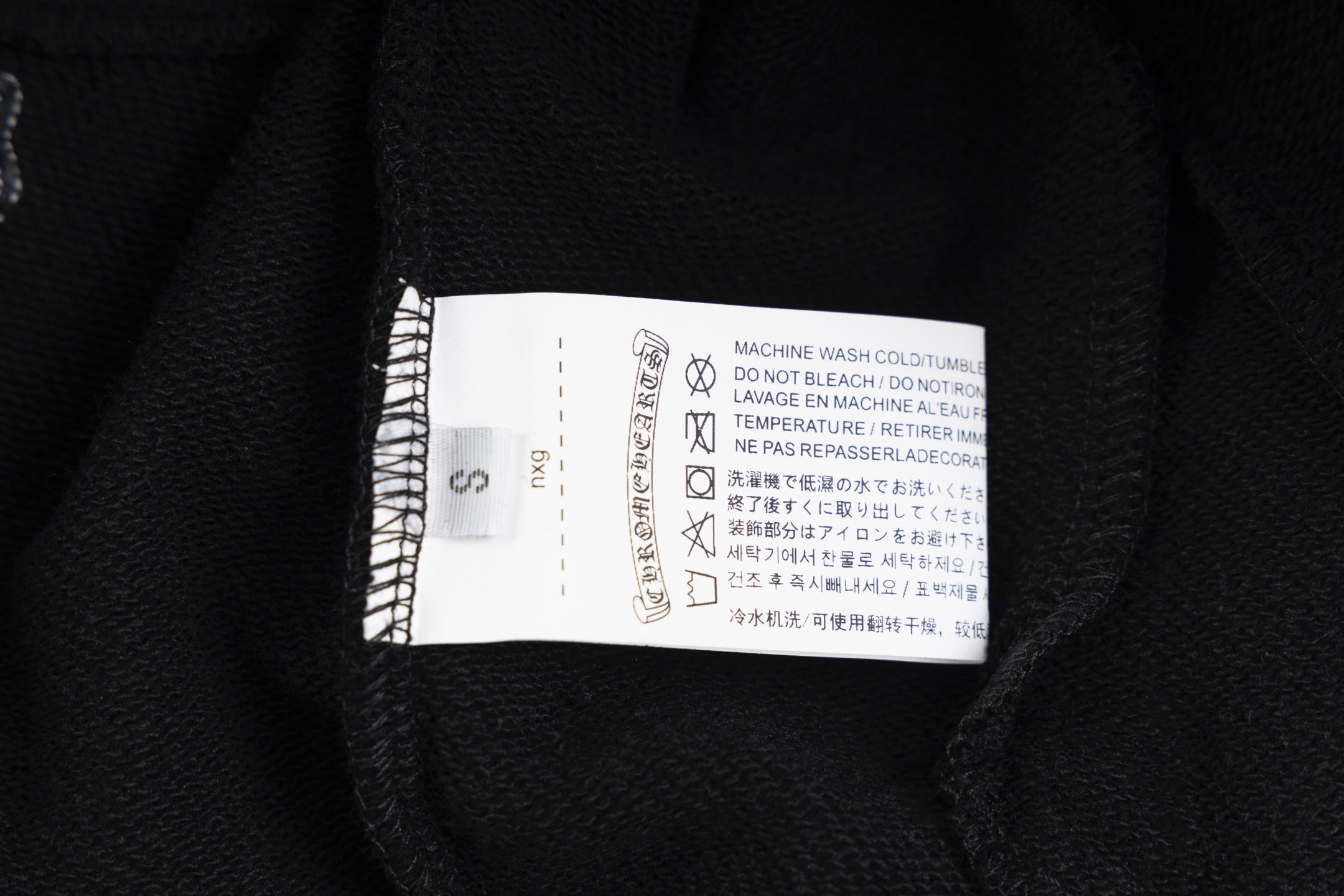 Black long-sleeve hoodie care label inside collar