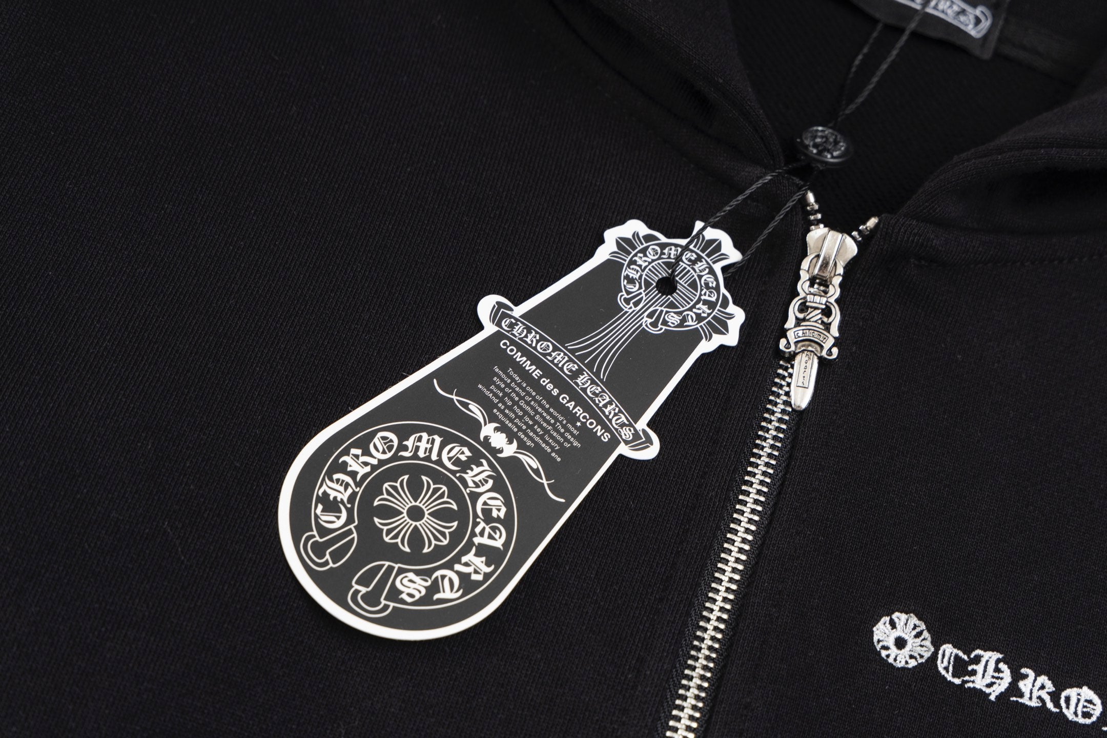 Black hoodie chest logo graphic and metal zipper teeth detail
