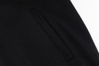 Black hoodie side seam and panel stitching detail near the hem