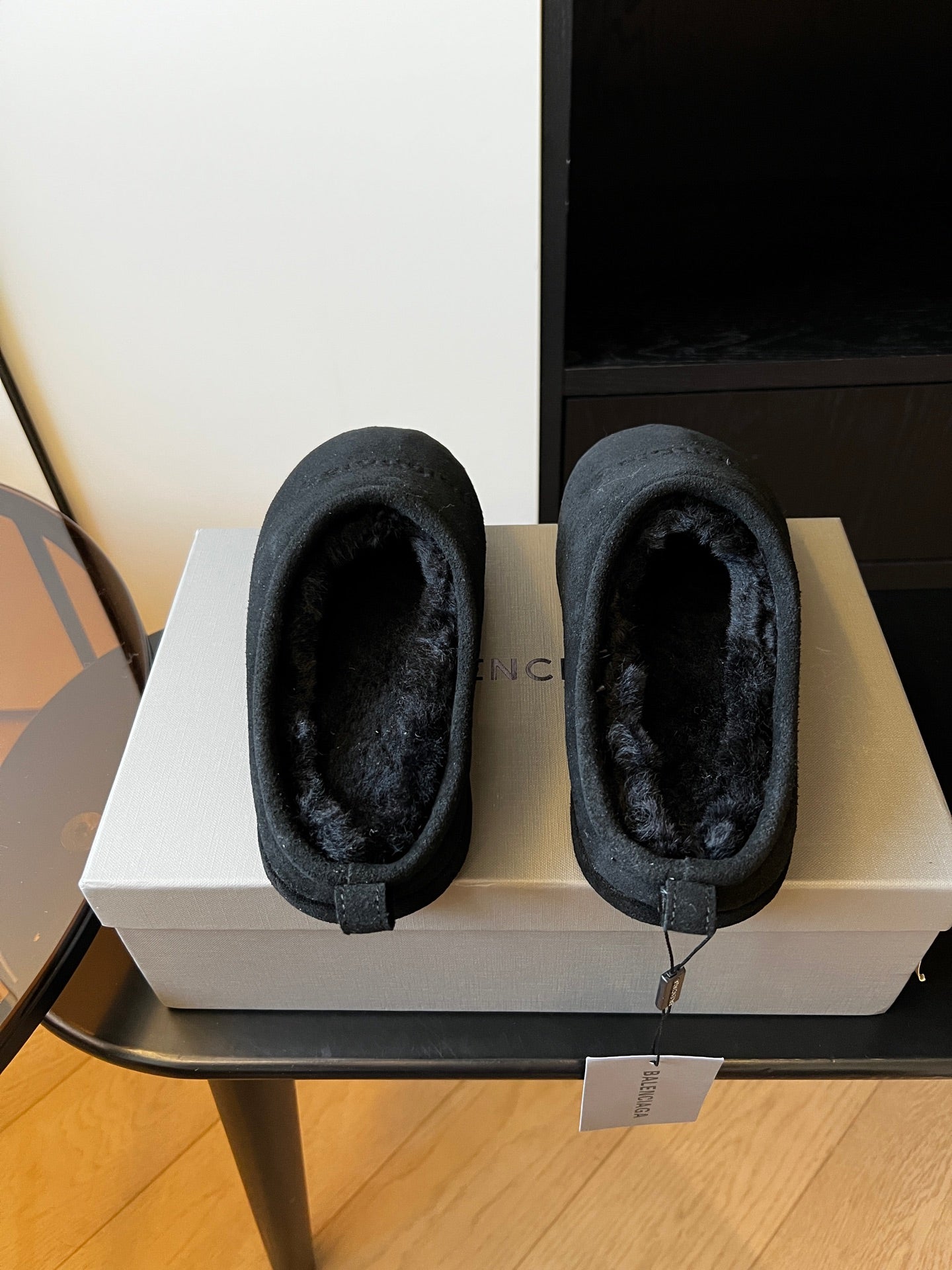 Balenciaga dark suede mules showing open toe and plush lining, boxed pair