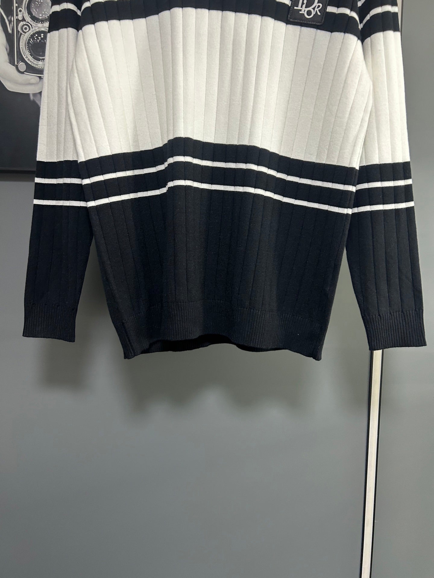 Long-sleeve knit polo sweater hem view with black and white horizontal stripe bands
