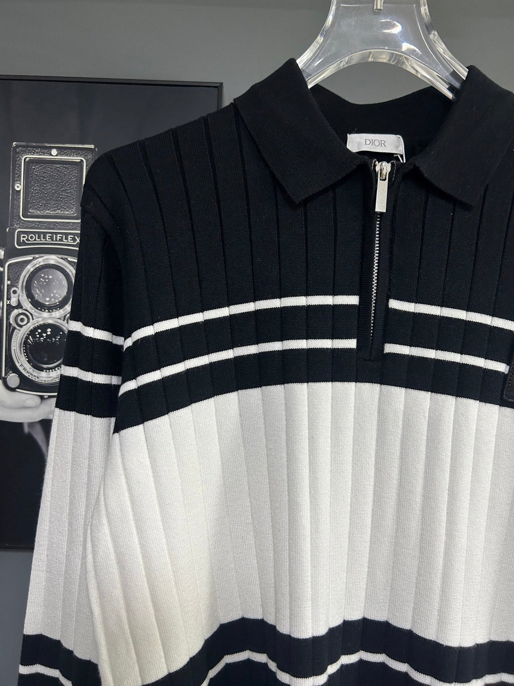 Long-sleeve knit polo sweater front close-up with horizontal stripes and Dior logo patch