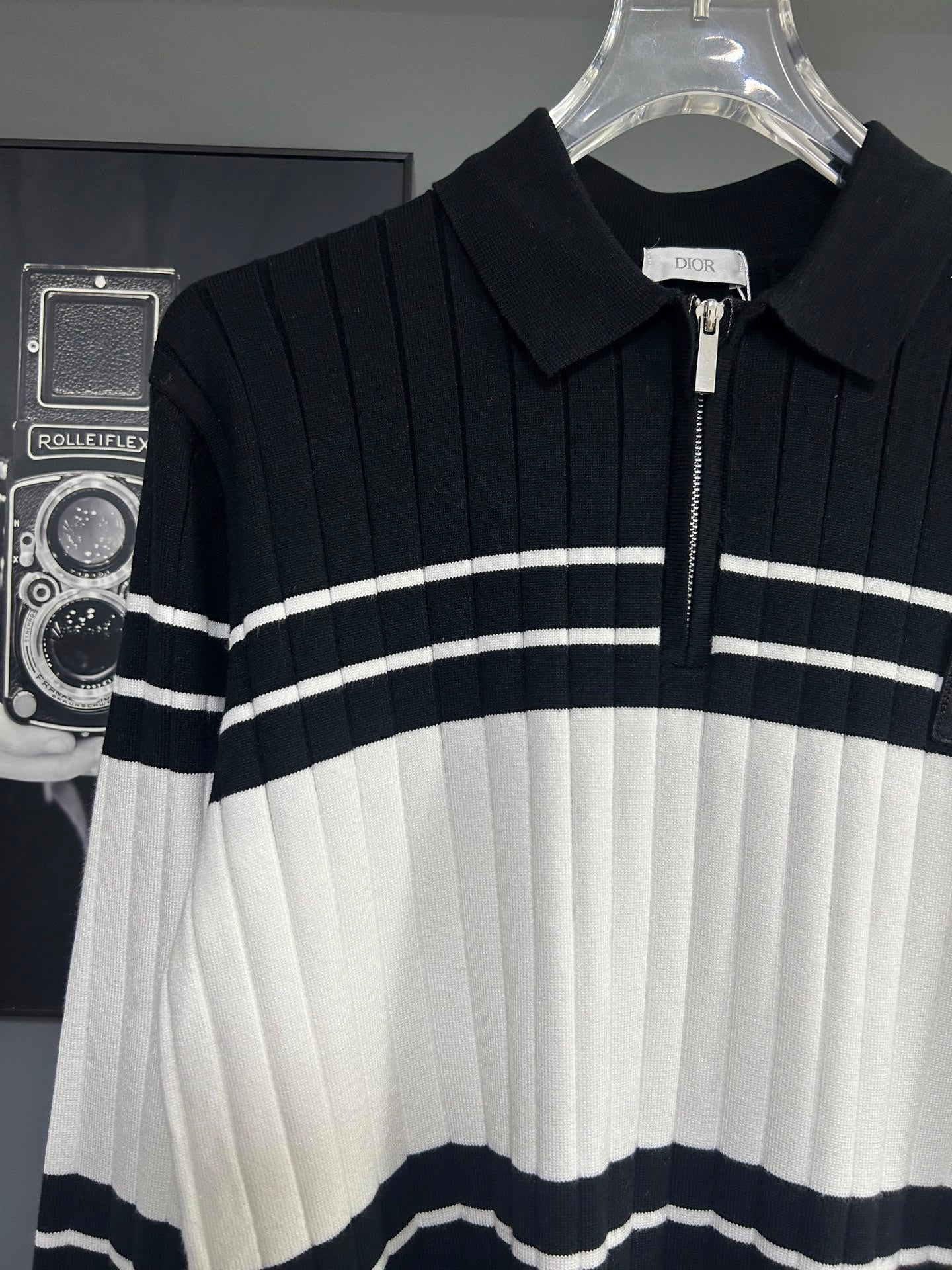 Long-sleeve knit polo sweater front close-up with horizontal stripes and Dior logo patch