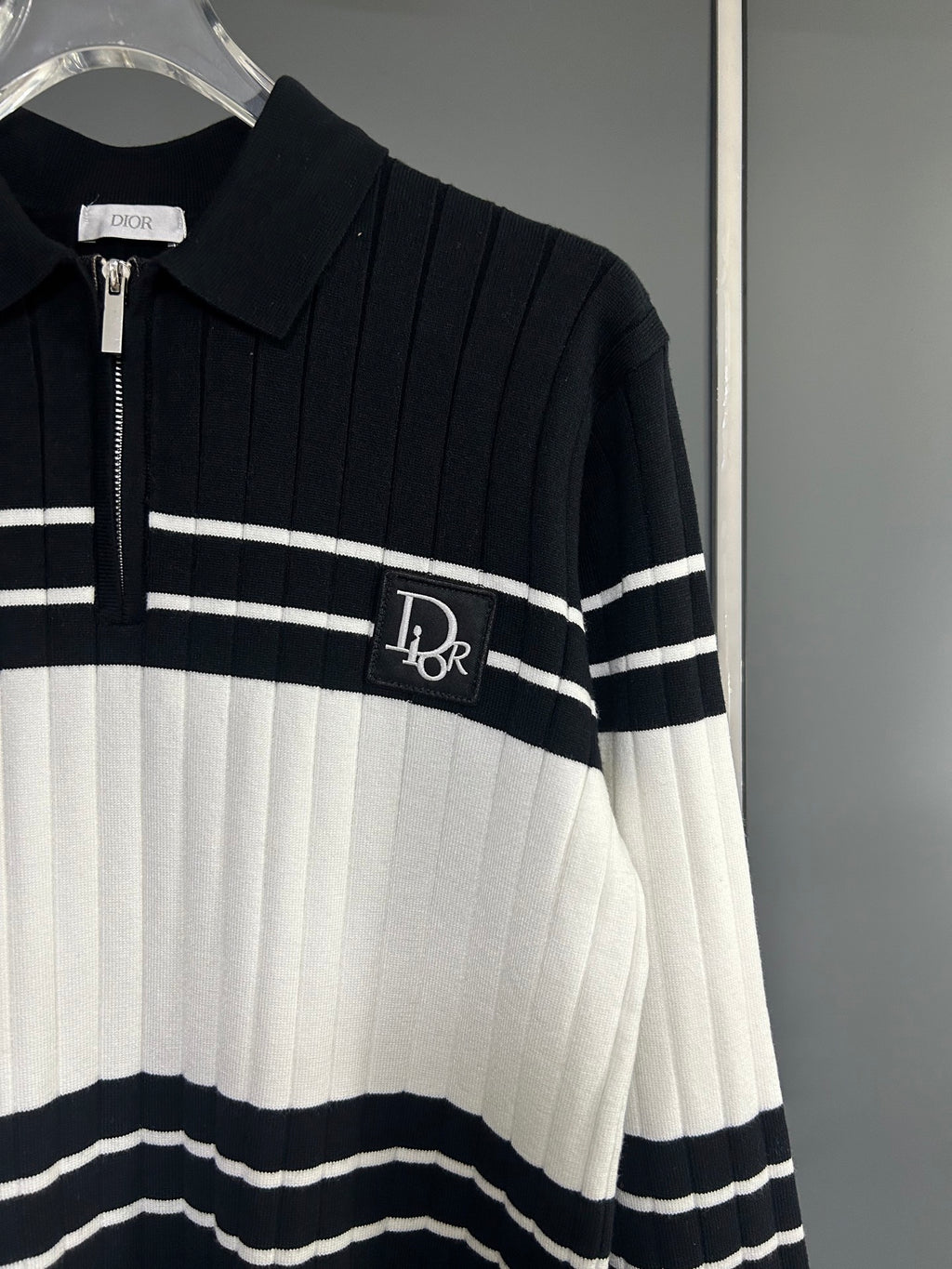 Long-sleeve knit polo sweater close-up: zip placket, ribbed collar, striped design