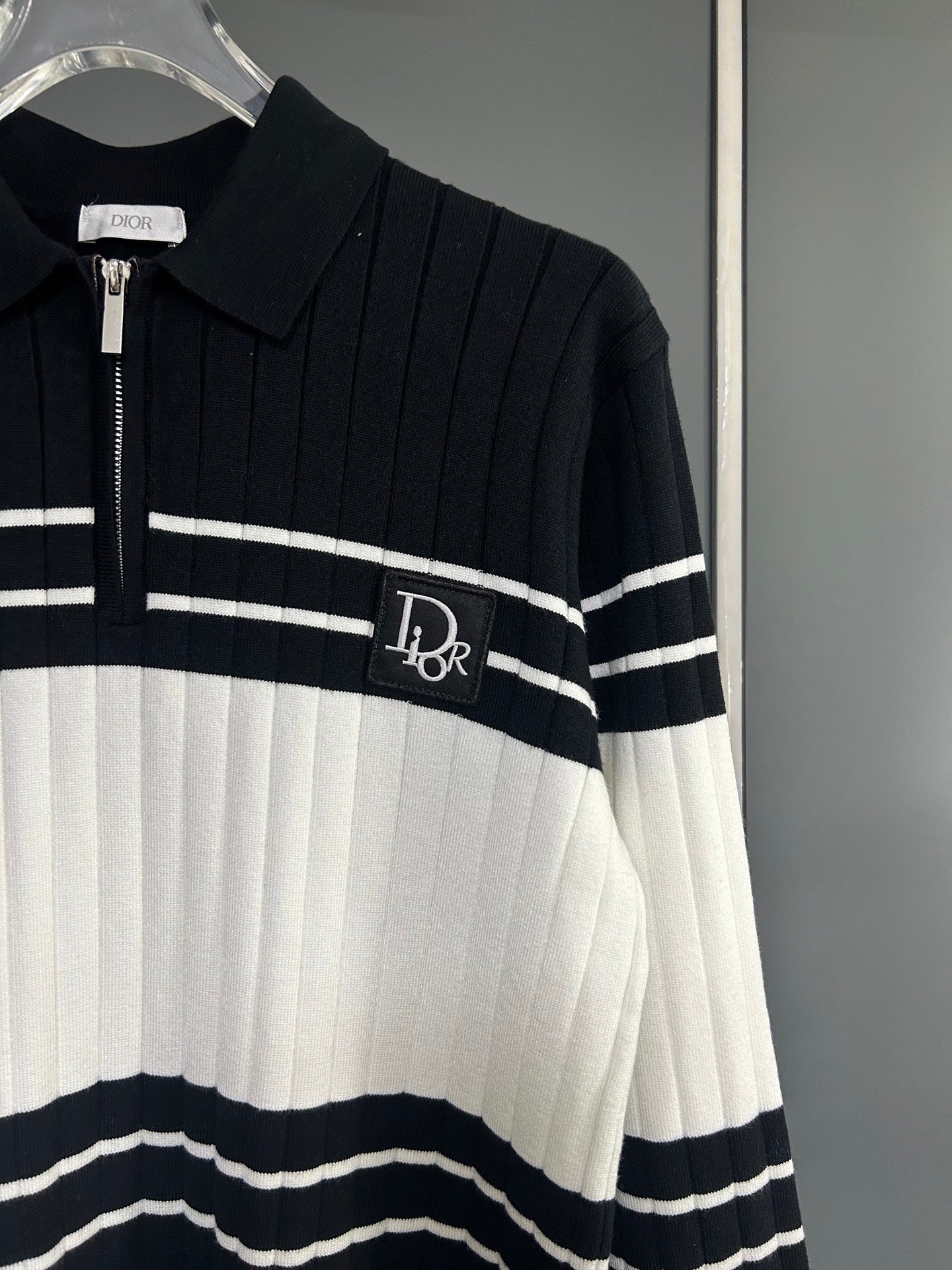 Long-sleeve knit polo sweater close-up: zip placket, ribbed collar, striped design