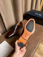 Dior unisex oxford shoe in hand showing orange CD logo insole card