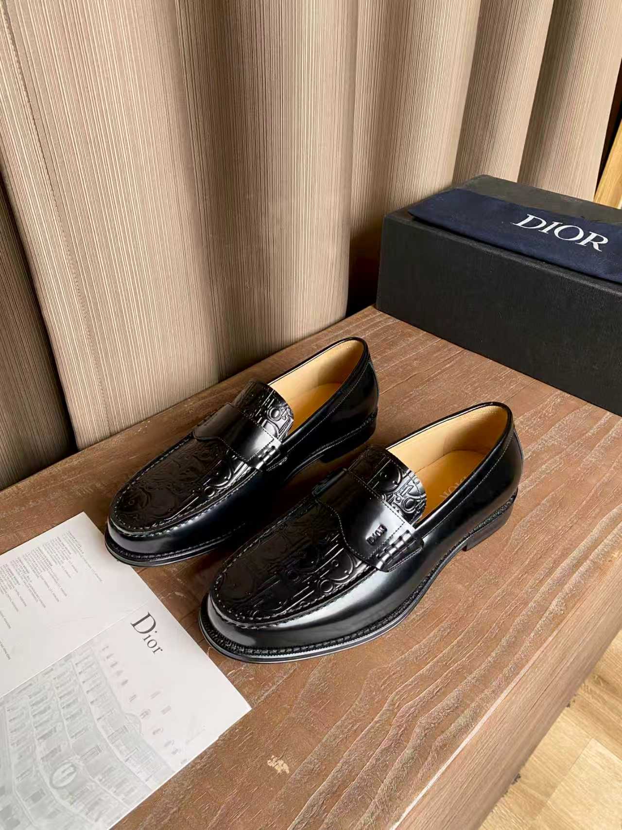 Black leather loafers with embossed texture and silver-tone buckle strap