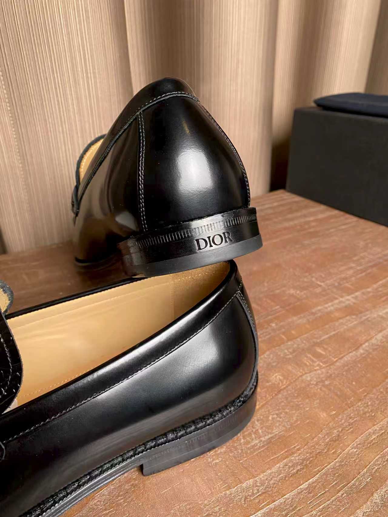 Black leather loafer close-up with rounded toe and engraved “DIOR” on heel