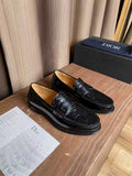 Black leather loafers with embossed detailing and silver-tone buckle hardware