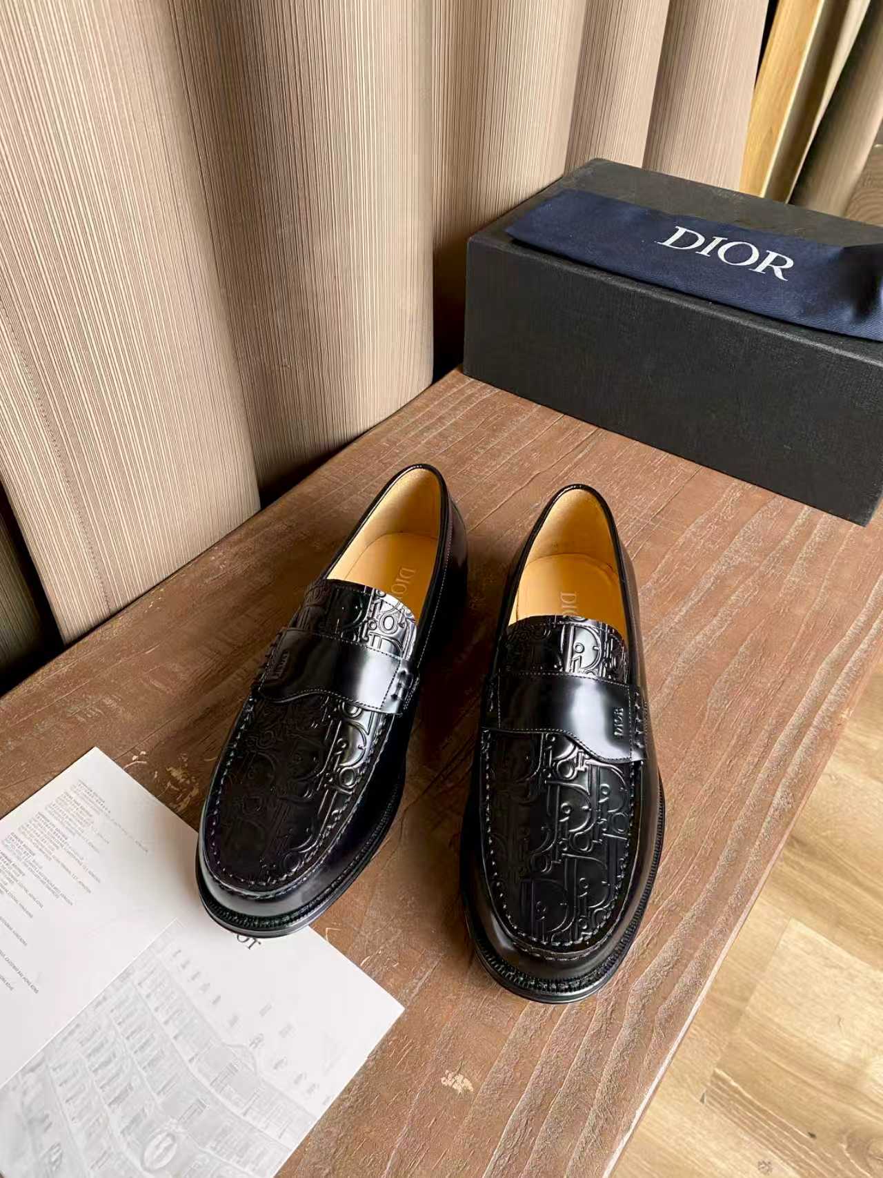 Black leather loafers with embossed ornament panel and silver-tone buckle