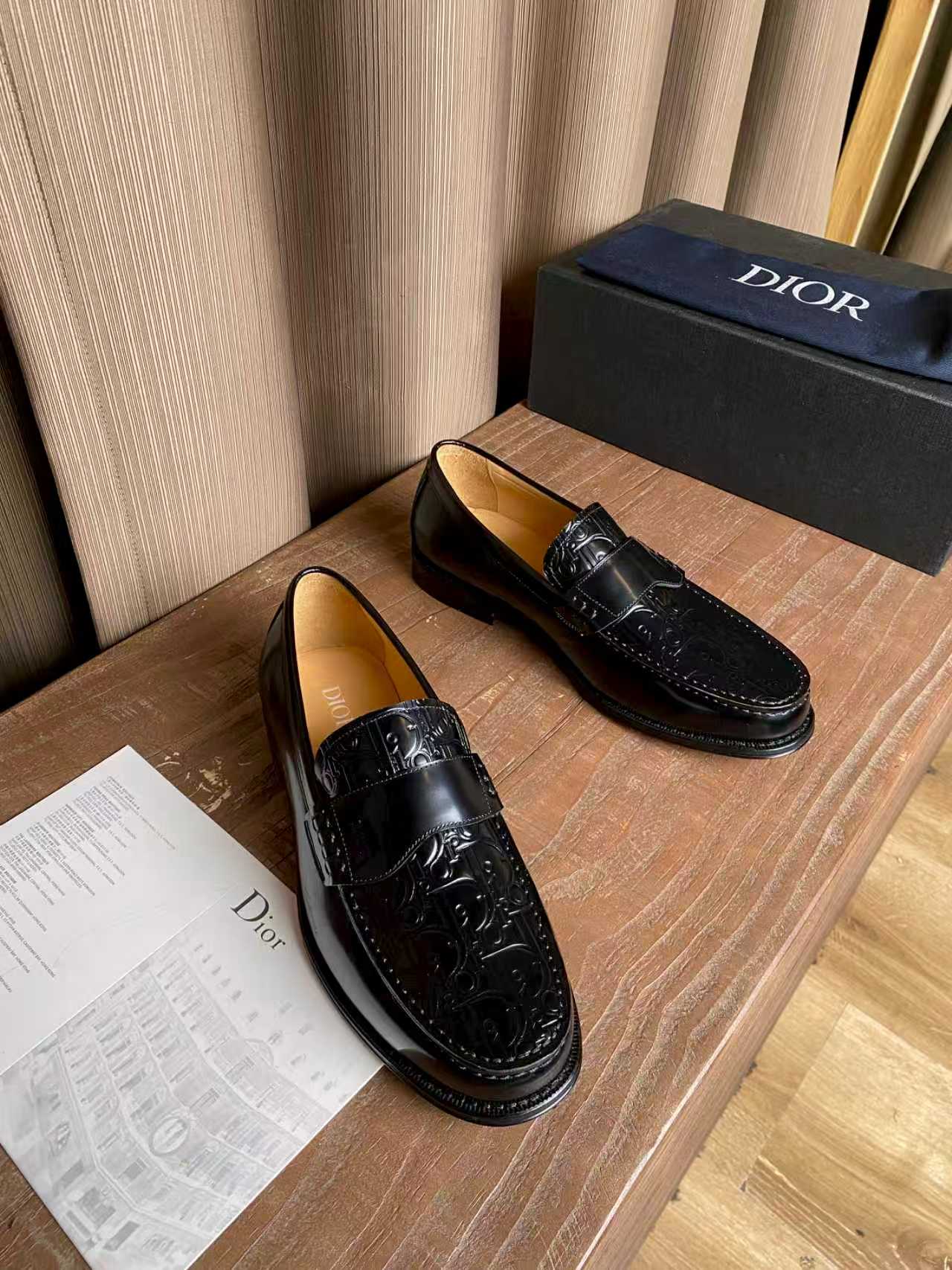 Pair of black leather loafers with embossed panel and silver-tone buckle hardware