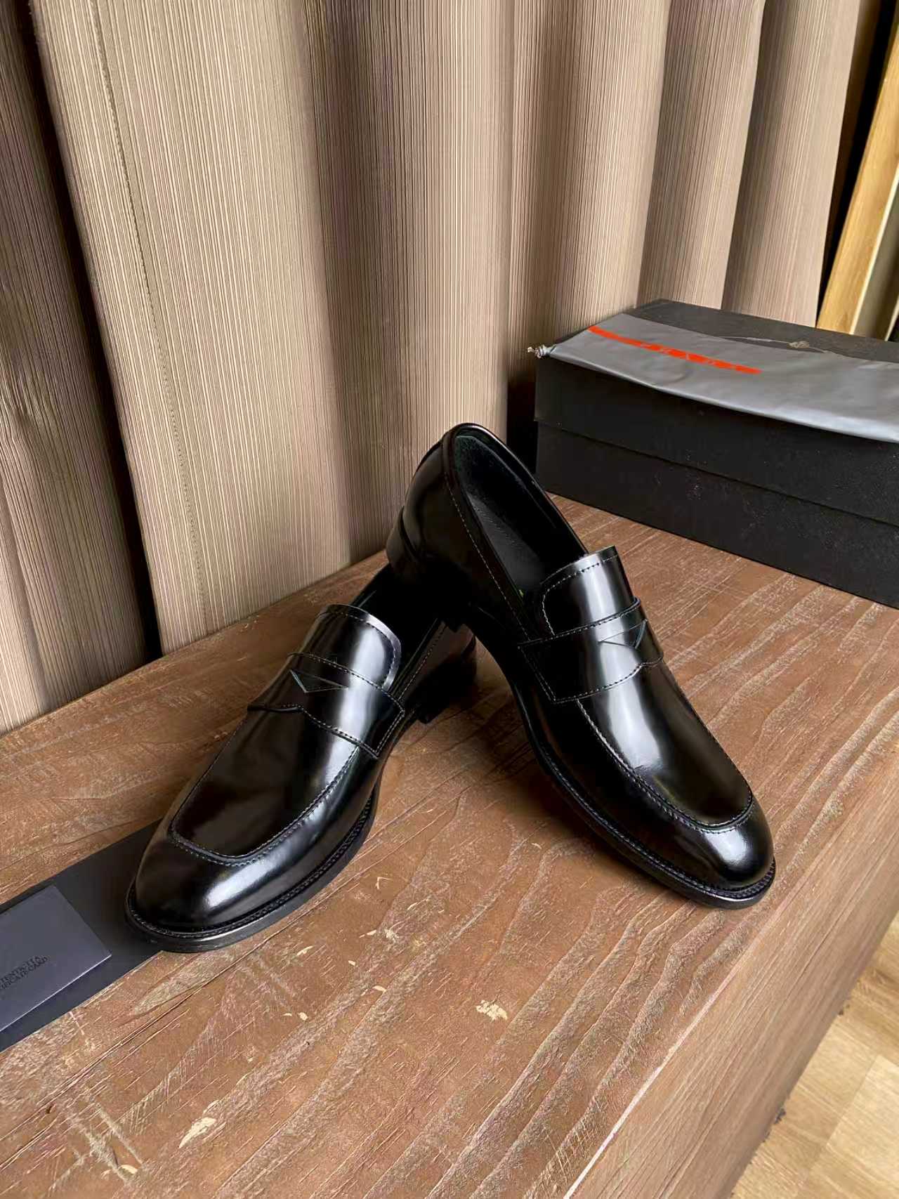 Prada unisex black leather loafers, side view with seam lines and moc-style stitching